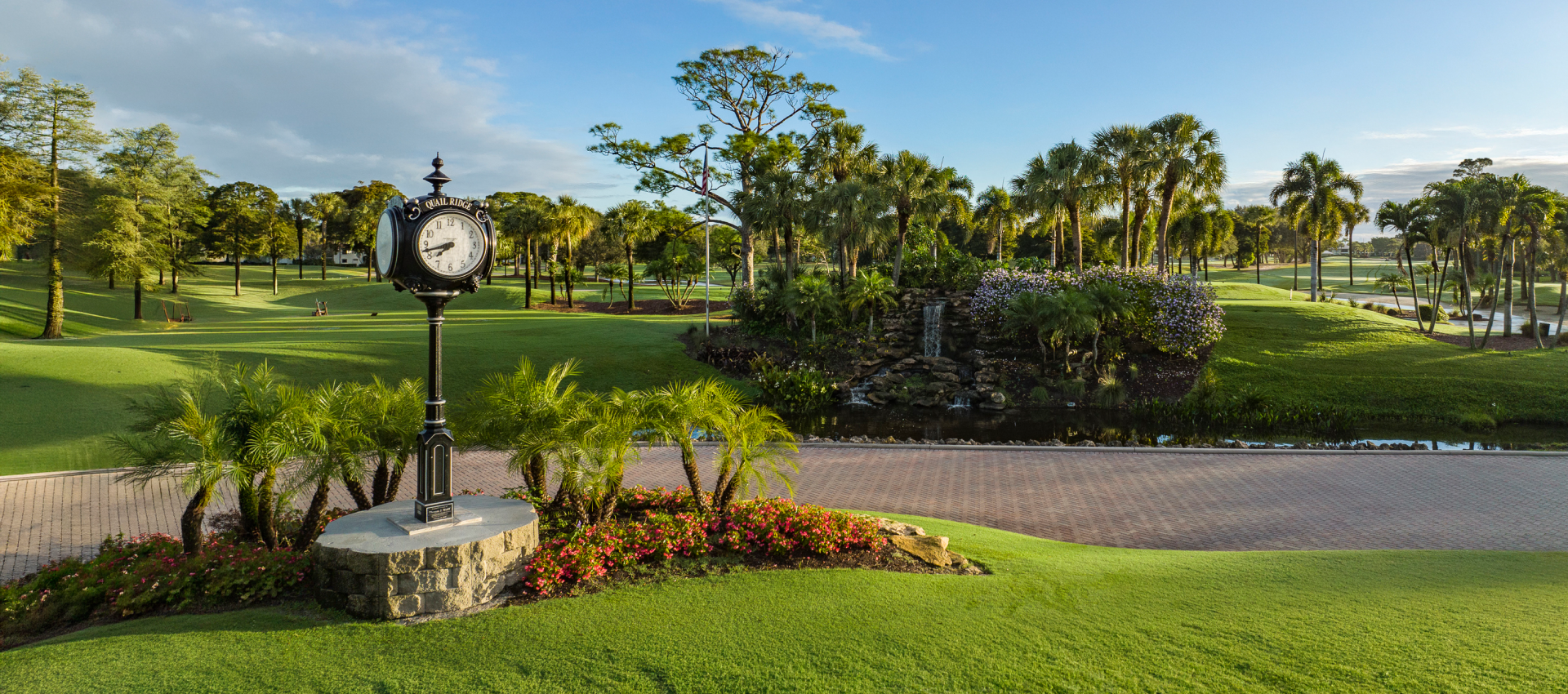 Golf course clock beside palm trees and pathway