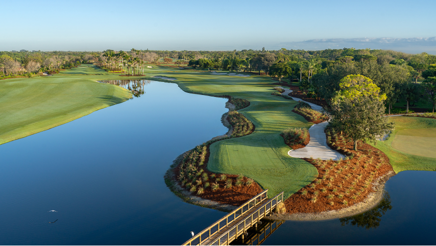Golf fairway beside a waterway with a small bridge