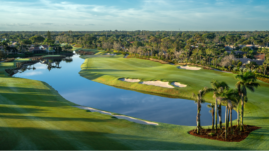 Aerial view of golf course with water and homes